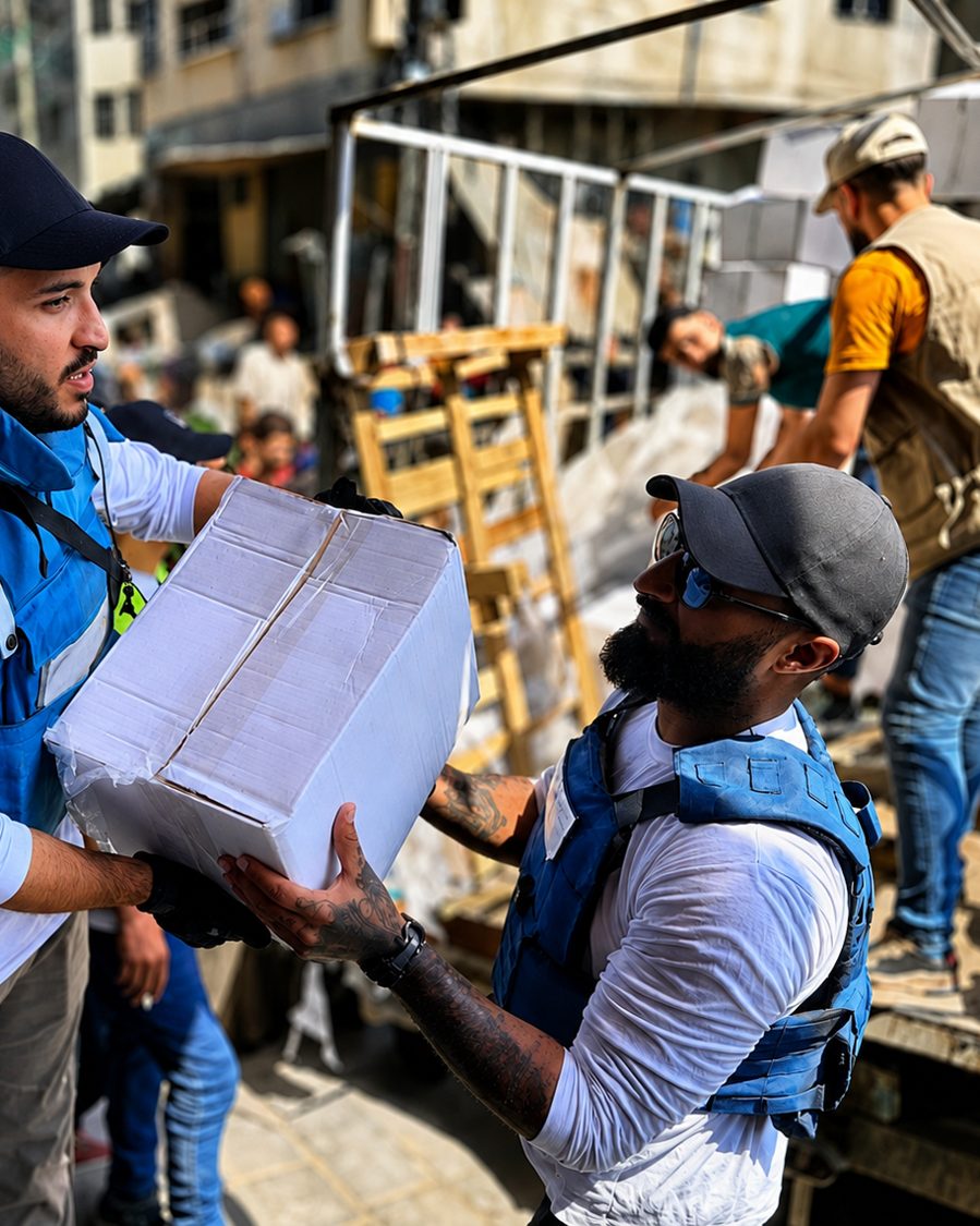 Aid being handed down from a truck to Benjamin Grant in Gaza