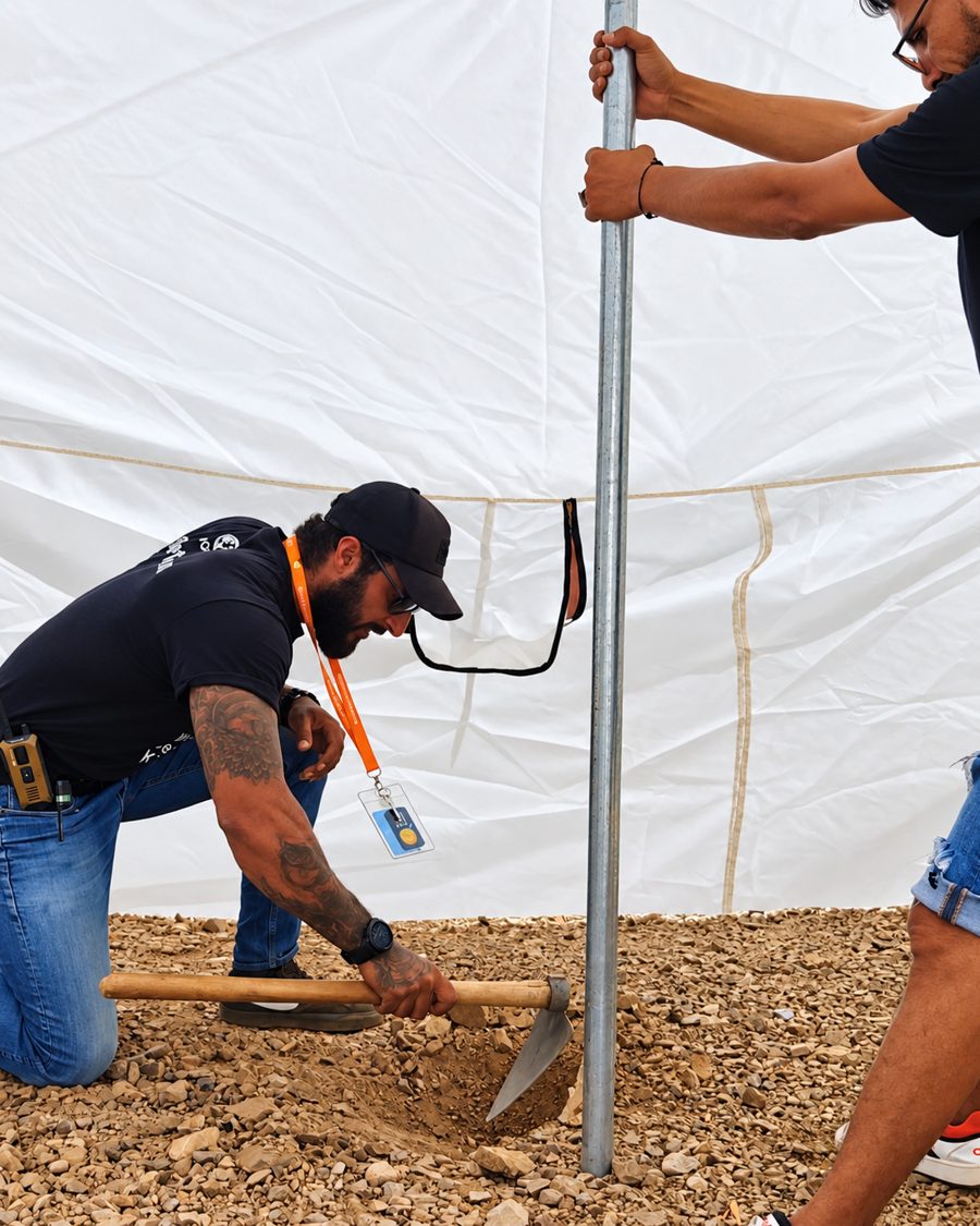 Benjamin Grant digging in a tent pole for a shelter in the Atlas Mountains